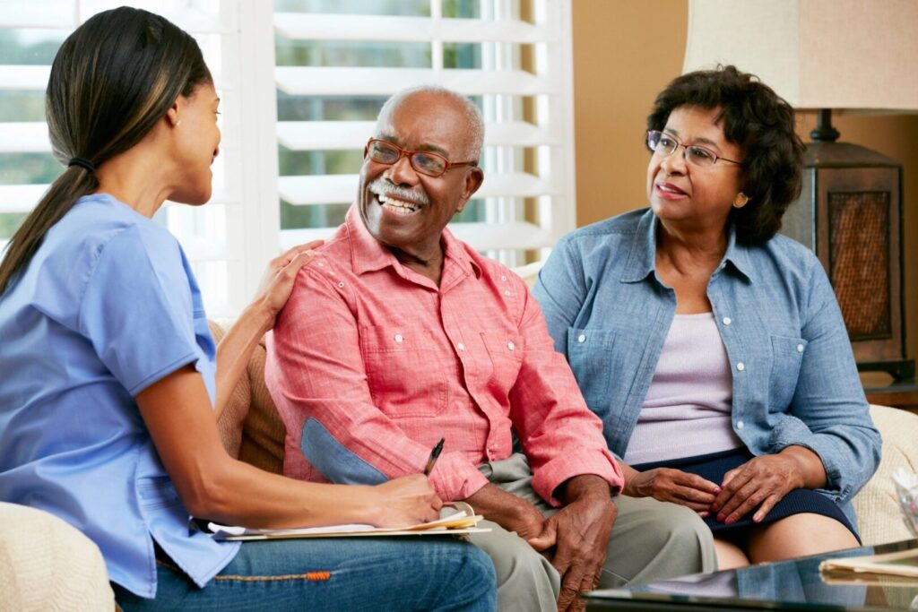 A nurse talking with an old man and his wife